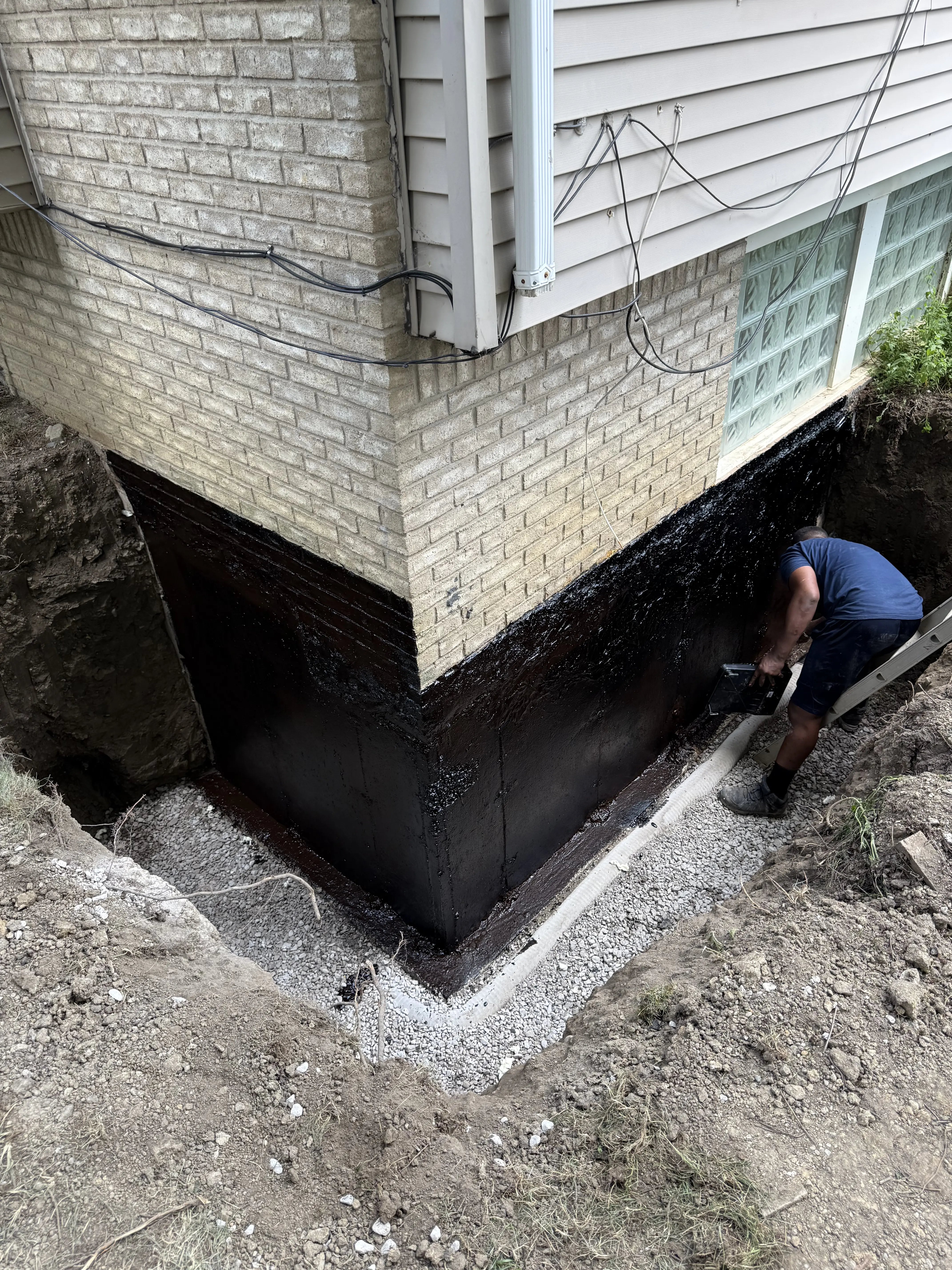 Waterproof membrane being installed on foundation
